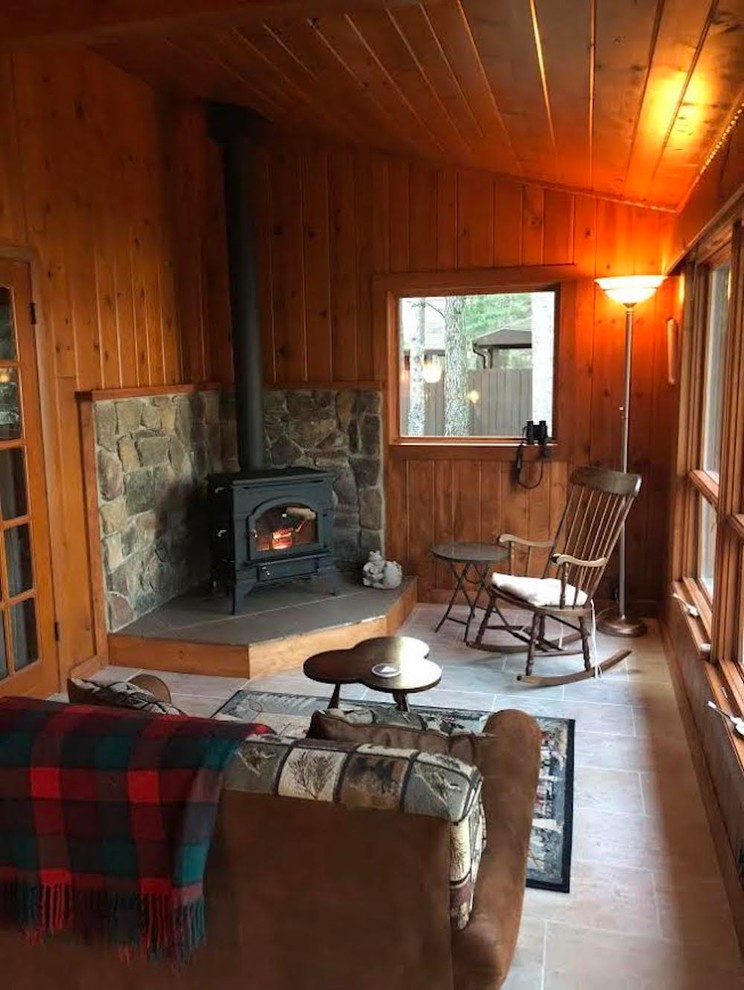 Example of a mid-sized classic travertine floor and beige floor sunroom design in Other with a hanging fireplace, a stone fireplace and a standard ceiling