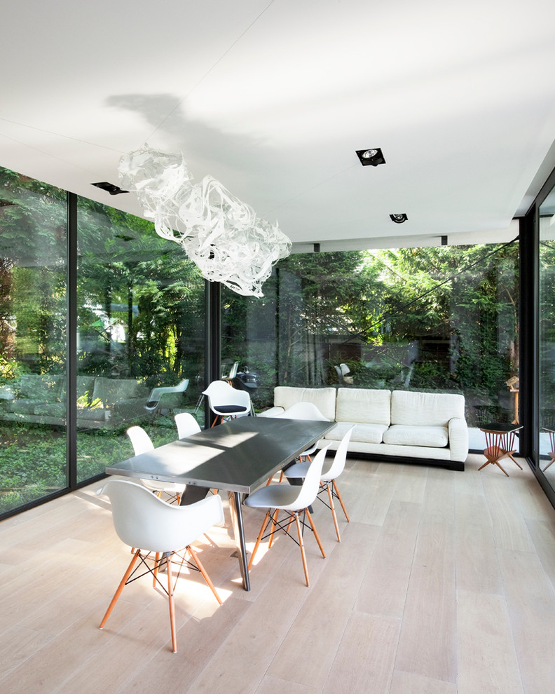 Photo of a modern conservatory in Brussels with light hardwood flooring and a standard ceiling.