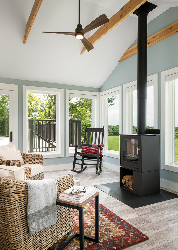 This is an example of a small traditional conservatory in Burlington with vinyl flooring, a wood burning stove, a metal fireplace surround and a standard ceiling.