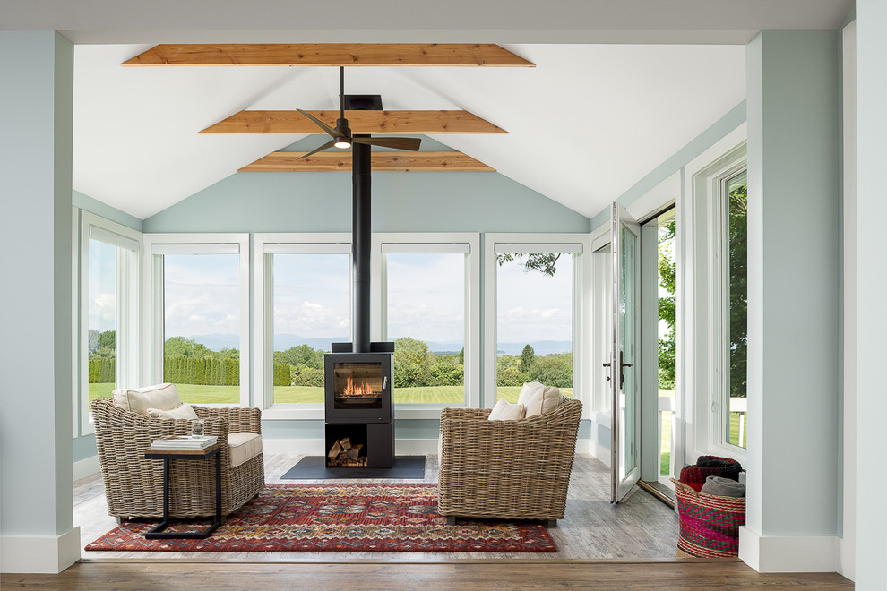 Immagine di una piccola veranda classica con pavimento in vinile, stufa a legna, cornice del camino in metallo e soffitto classico