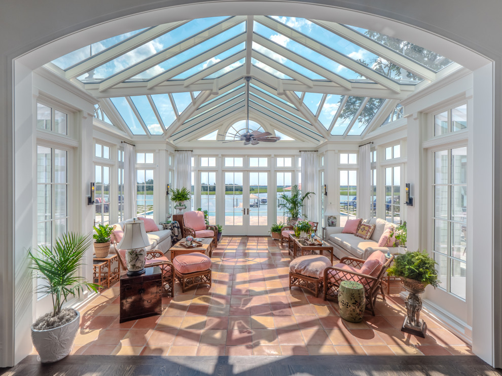 This is an example of a traditional conservatory in Other with terracotta flooring, a glass ceiling and red floors.