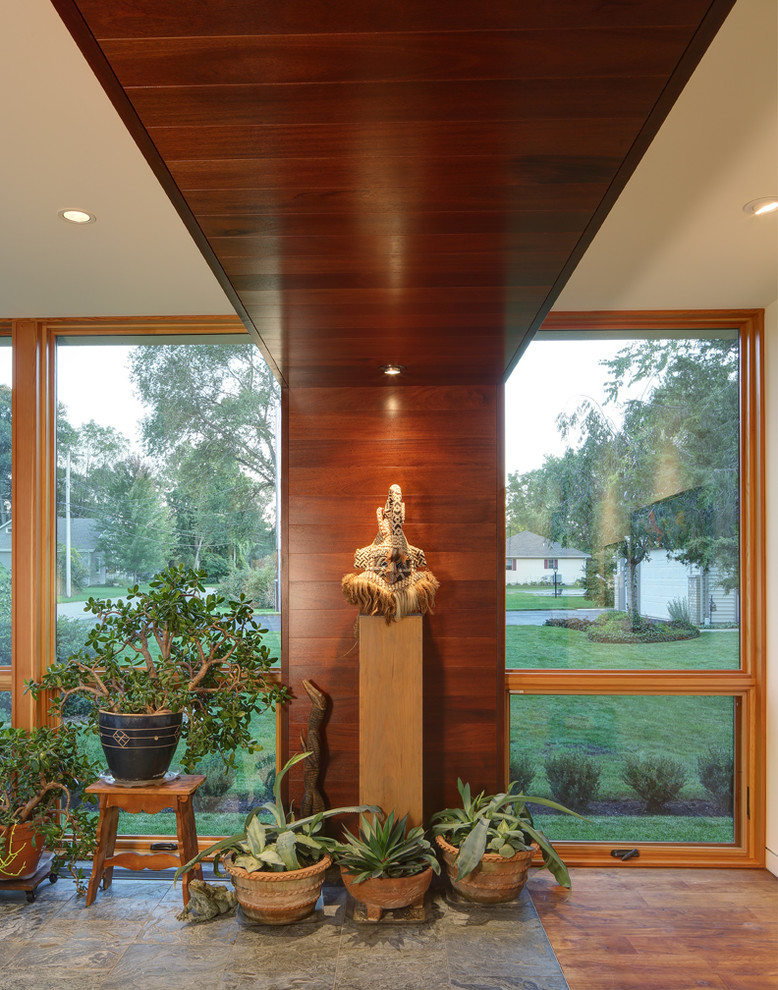 Immagine di una veranda moderna di medie dimensioni con pavimento in legno massello medio e soffitto classico