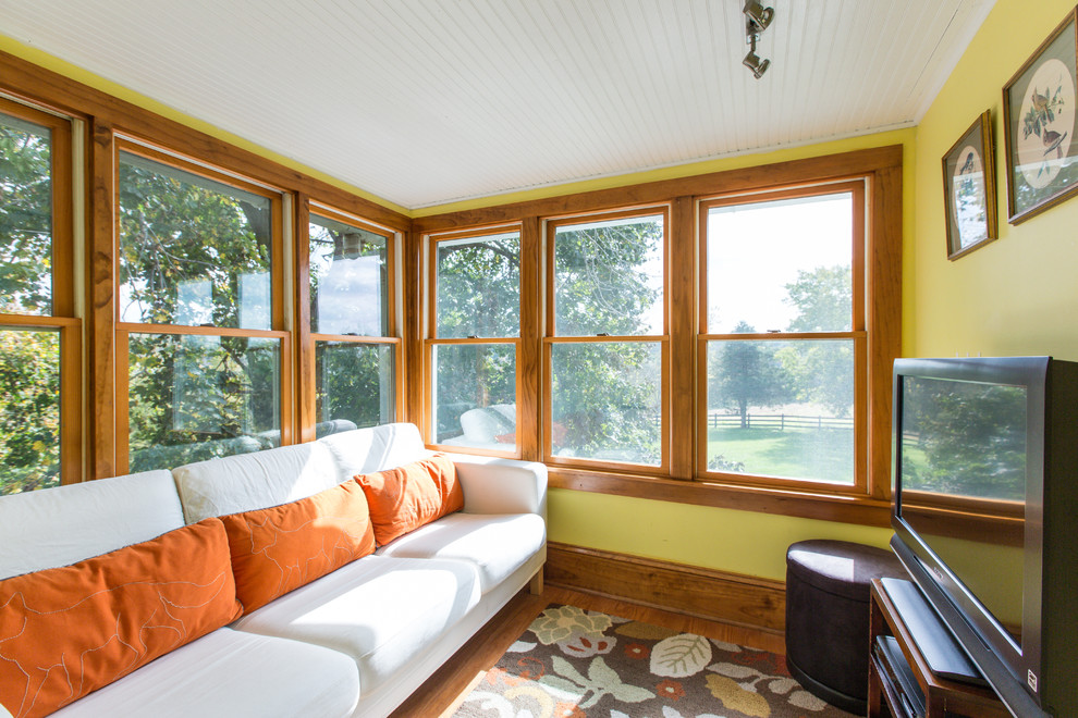 Idée de décoration pour une véranda champêtre de taille moyenne avec un sol en bois brun et un plafond standard.