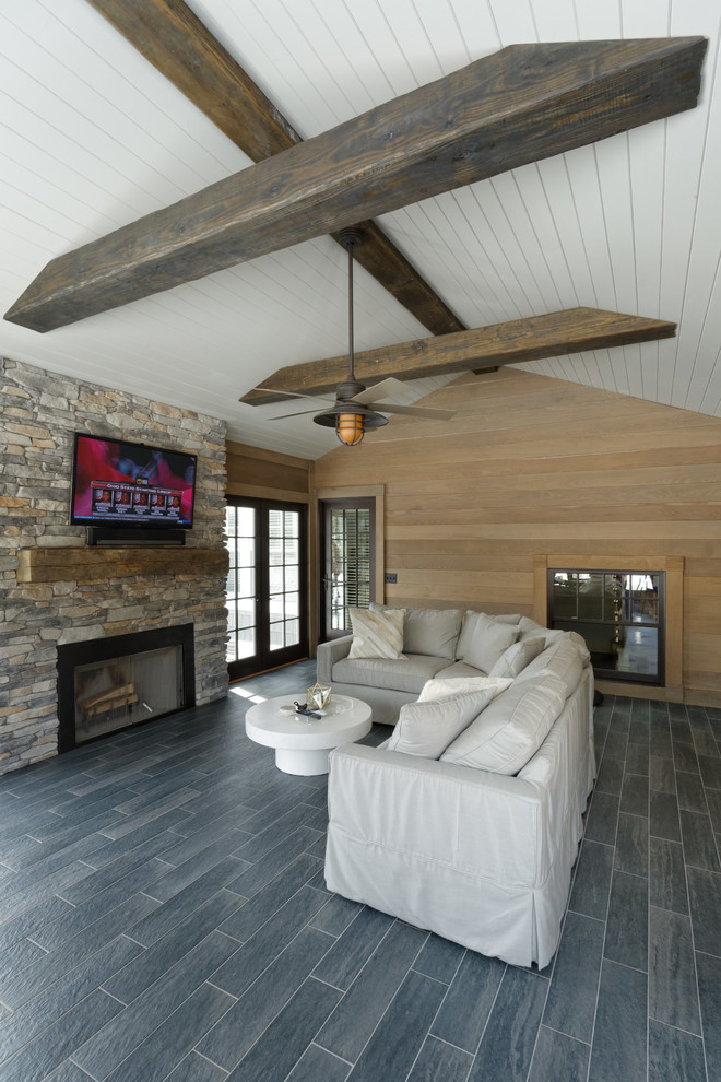Aménagement d'une véranda classique de taille moyenne avec parquet foncé, une cheminée standard, un manteau de cheminée en pierre, un plafond standard et un sol marron.