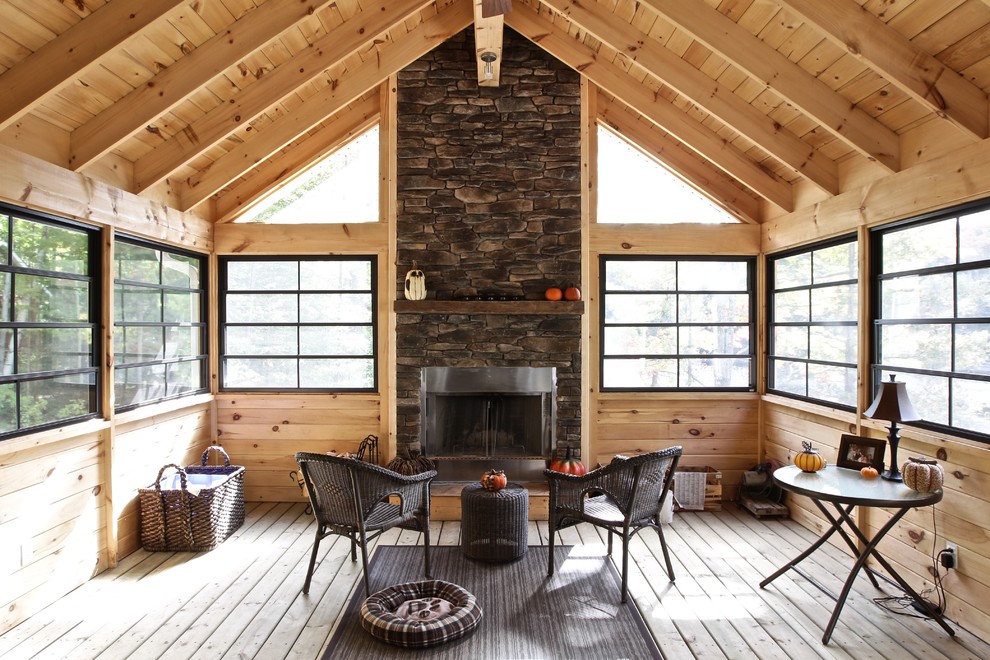 Imagen de galería rústica con suelo de madera en tonos medios, techo estándar, marco de chimenea de metal y suelo marrón
