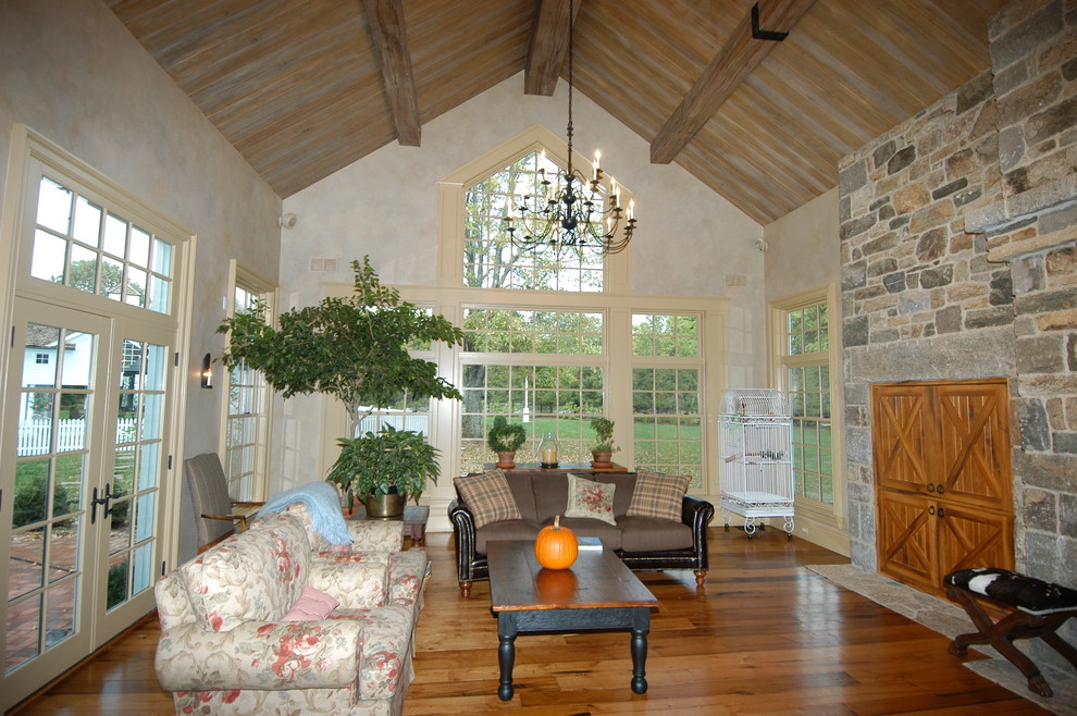 Immagine di una veranda tradizionale con pavimento in legno massello medio, soffitto classico e pavimento marrone