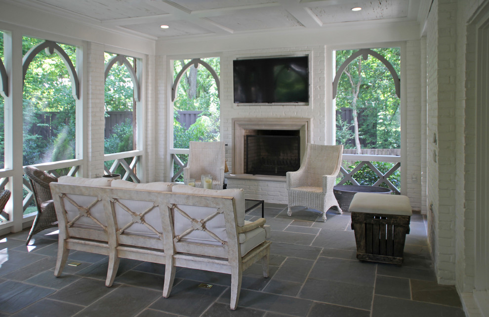 Foto di una veranda tradizionale di medie dimensioni con camino classico, cornice del camino in mattoni, pavimento grigio, pavimento in ardesia e soffitto classico