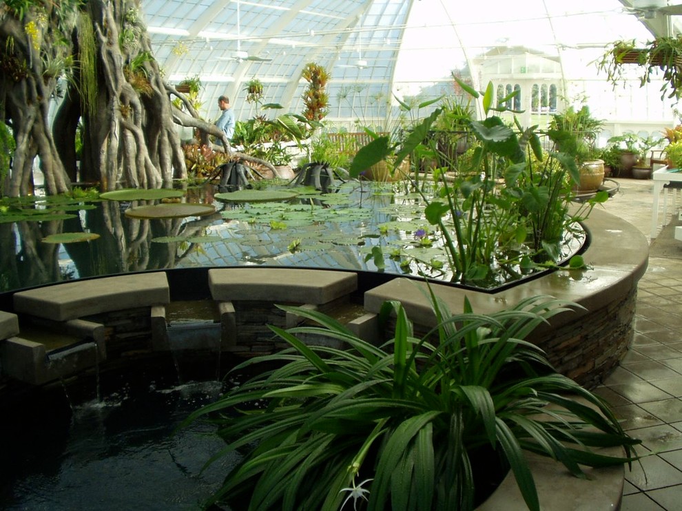 Esempio di un'ampia veranda tropicale con pavimento in cemento e soffitto in vetro
