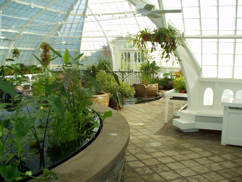 This is an example of an expansive world-inspired conservatory in San Francisco with concrete flooring and a glass ceiling.