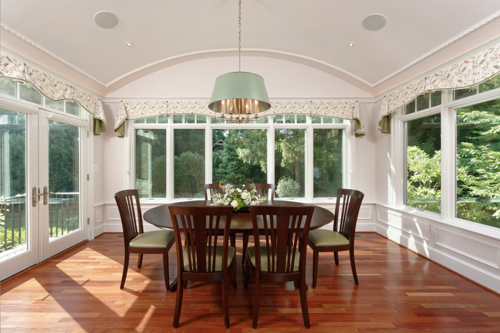 This is an example of a classic conservatory in DC Metro with medium hardwood flooring and brown floors.