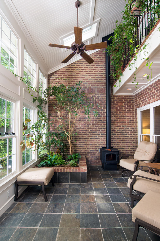 Esempio di una veranda tradizionale di medie dimensioni con pavimento con piastrelle in ceramica, stufa a legna, lucernario e pavimento multicolore