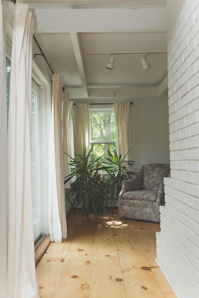 Foto di una veranda moderna con pavimento in legno massello medio e nessun camino