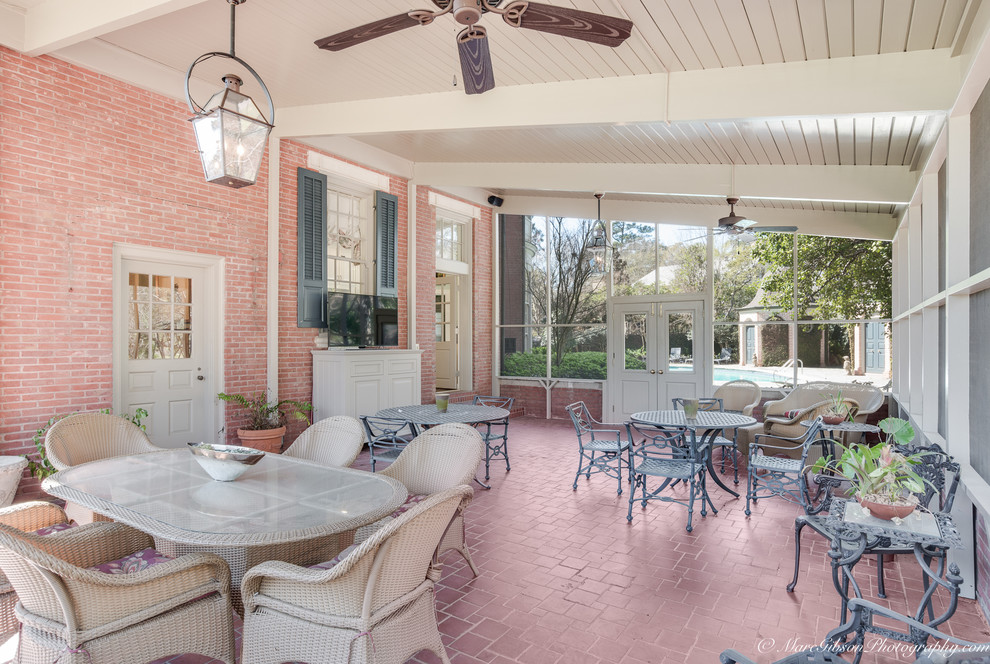 Huge elegant brick floor sunroom photo in New Orleans with no fireplace and a standard ceiling