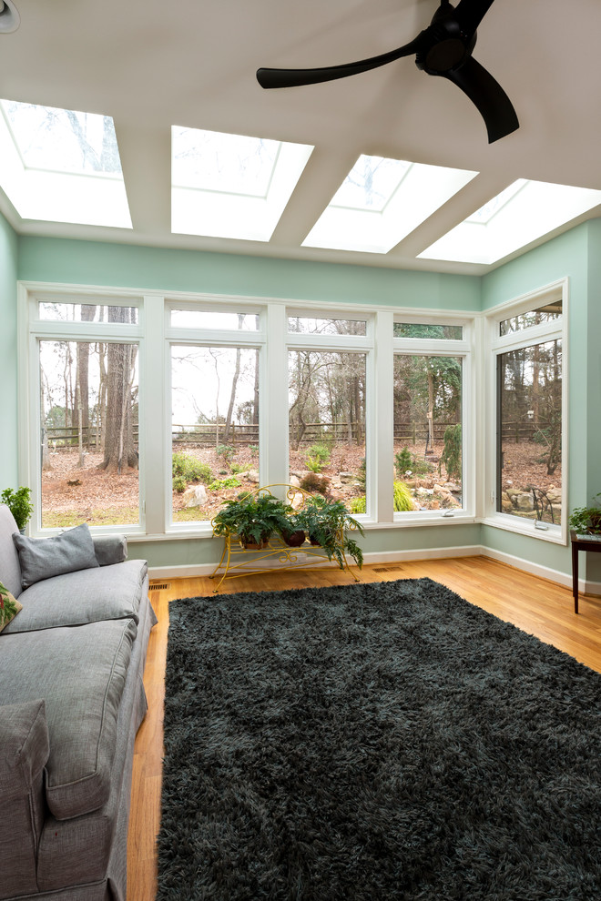 Esempio di una veranda contemporanea di medie dimensioni con pavimento in legno massello medio, lucernario e pavimento marrone