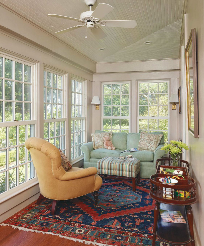 Immagine di una grande veranda classica con pavimento in legno massello medio