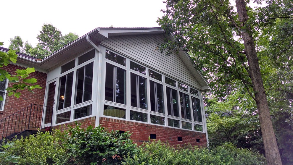 Esempio di una grande veranda classica con pavimento in cemento e soffitto classico