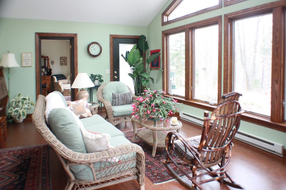 This is an example of a medium sized rustic conservatory in Grand Rapids with no fireplace, a standard ceiling and cork flooring.