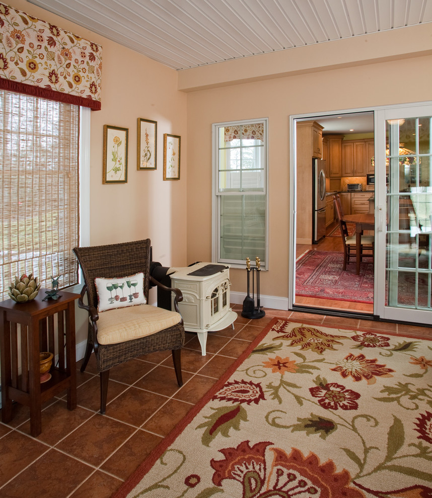 Medium sized eclectic conservatory in Philadelphia with terracotta flooring and a wood burning stove.