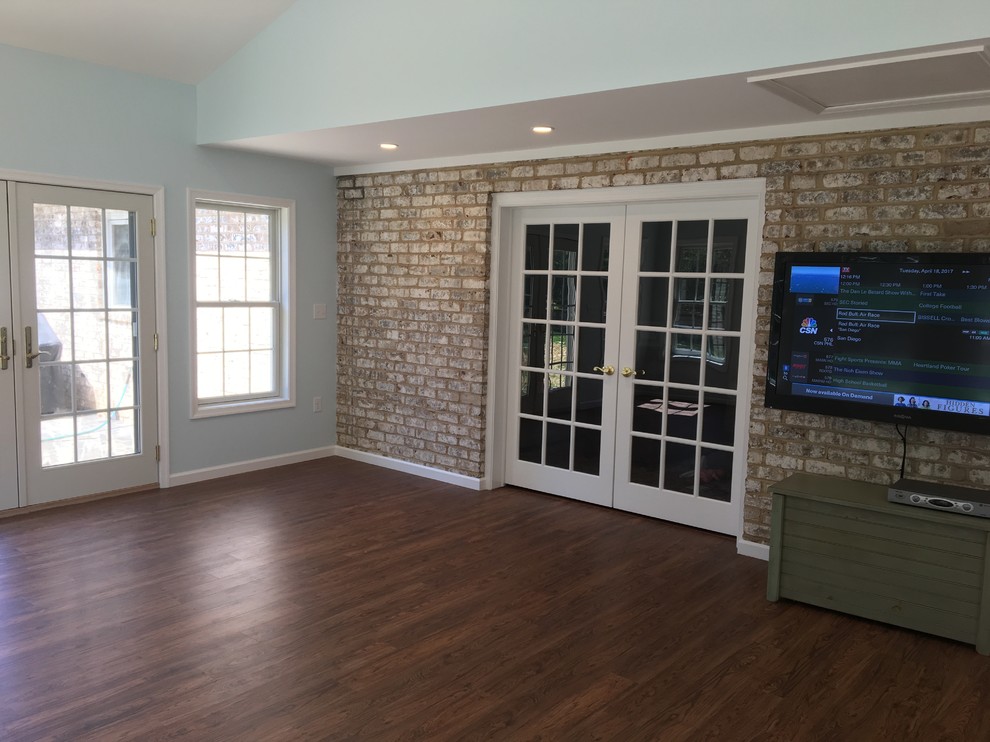 Example of a large classic dark wood floor and brown floor sunroom design in Other with a corner fireplace, a wood fireplace surround and a standard ceiling
