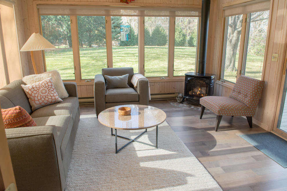 This is an example of a medium sized midcentury conservatory in Minneapolis with laminate floors, a corner fireplace, a metal fireplace surround, a standard ceiling and multi-coloured floors.