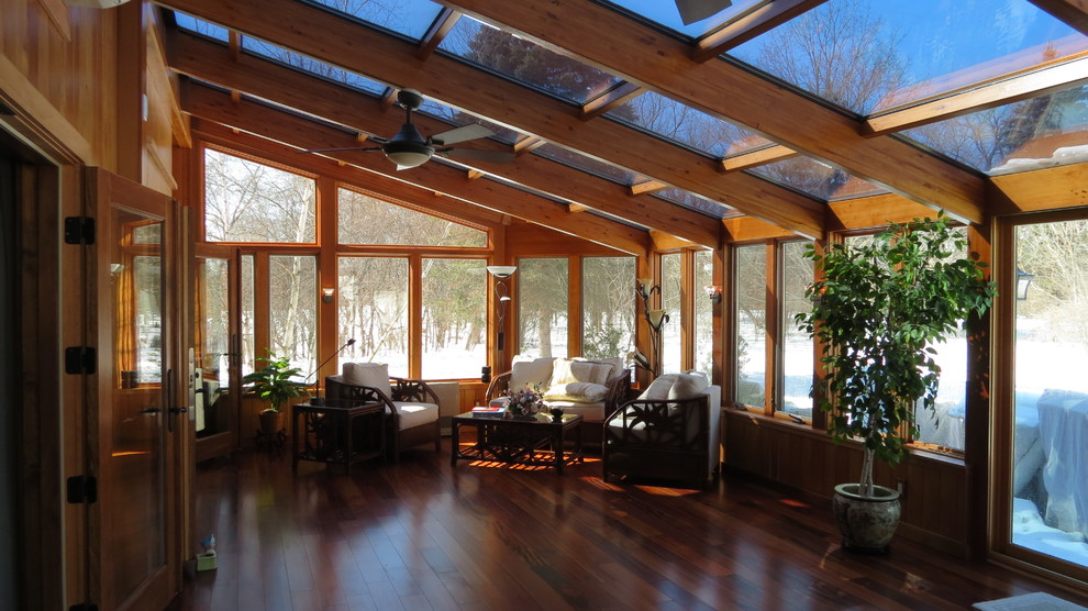 Idee per una grande veranda chic con pavimento in legno massello medio, nessun camino, lucernario e pavimento marrone
