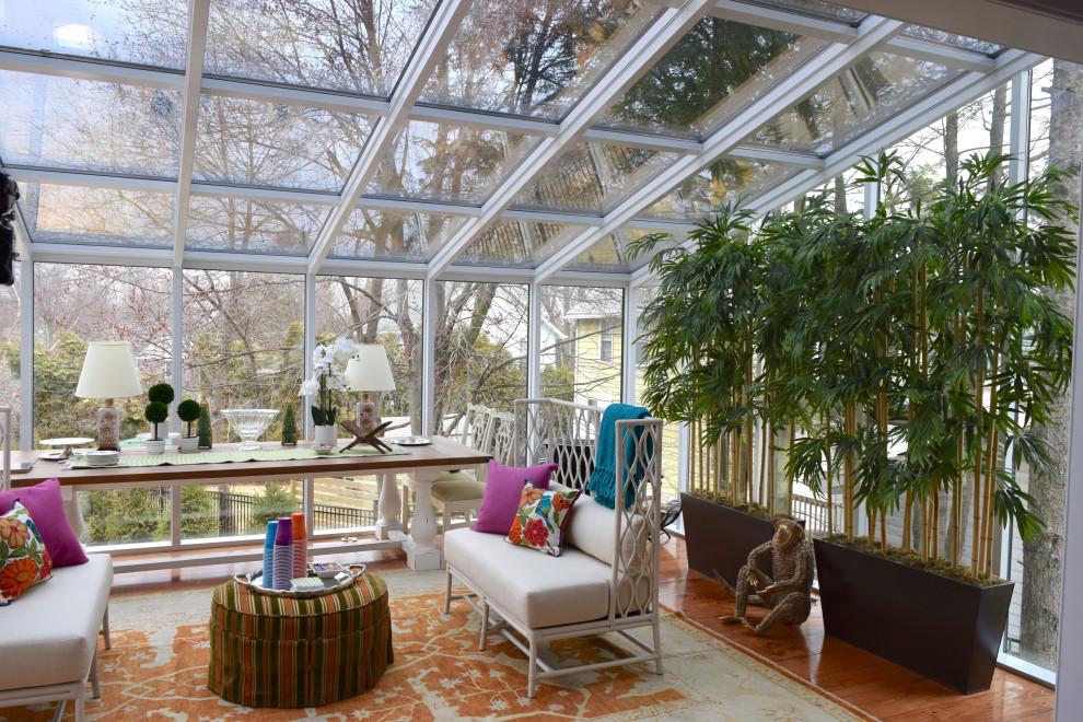 Foto di una veranda contemporanea con pavimento in legno massello medio, soffitto in vetro e pavimento marrone
