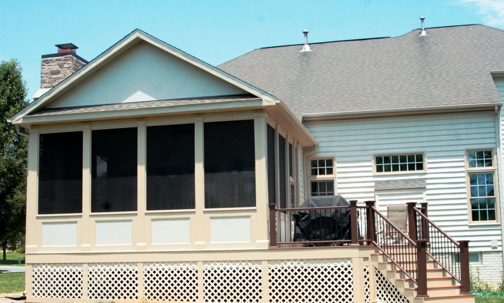 Foto di una grande veranda tradizionale con parquet chiaro, camino classico, cornice del camino in pietra, soffitto classico e pavimento marrone