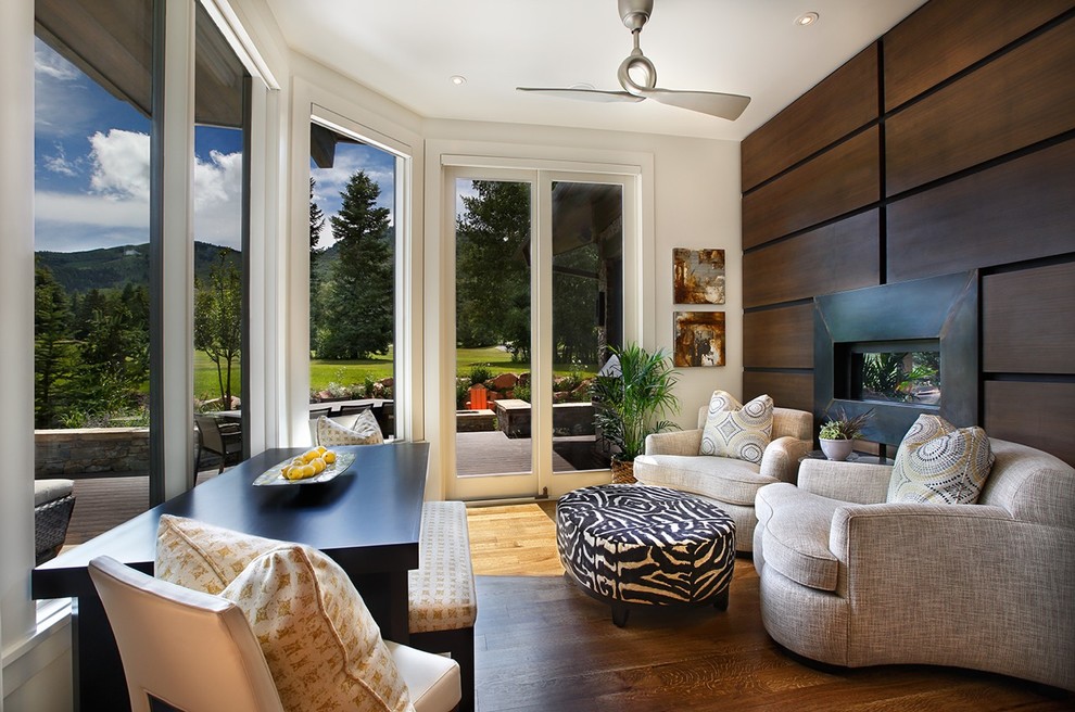 Esempio di una veranda minimal con parquet chiaro, camino classico, cornice del camino in metallo, soffitto classico e pavimento marrone