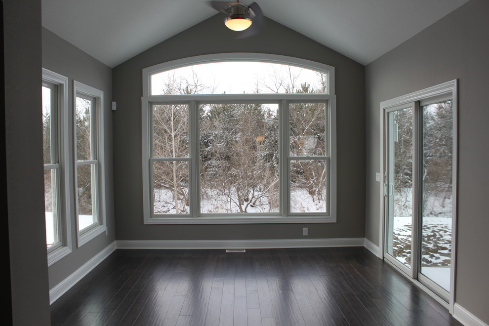 This is an example of a classic conservatory in Other with dark hardwood flooring.