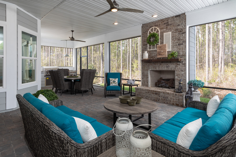 Esempio di una veranda country con camino classico, cornice del camino in mattoni, soffitto classico e pavimento marrone
