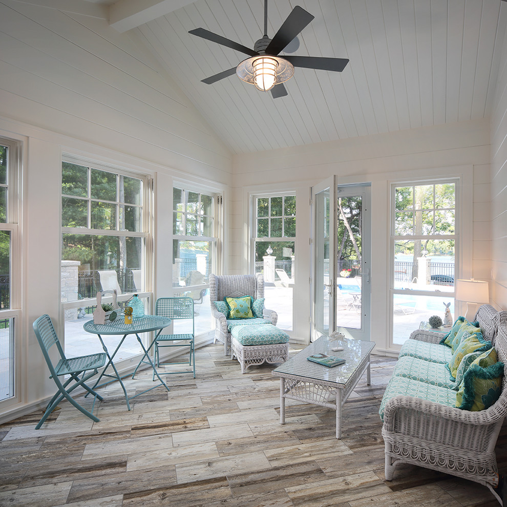 Photo of a coastal conservatory in Milwaukee with light hardwood flooring, a standard ceiling and grey floors.