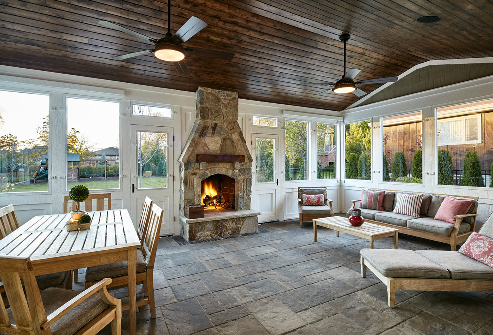 Foto di una veranda rustica con camino classico, cornice del camino in pietra e soffitto classico