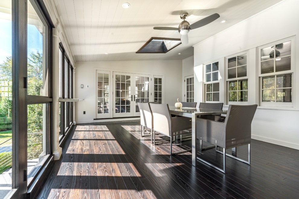Example of a transitional dark wood floor and brown floor sunroom design in New York with a skylight