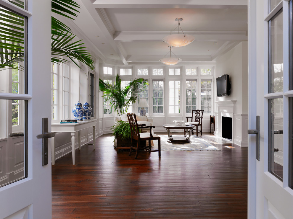 Immagine di una grande veranda classica con parquet scuro, camino classico, soffitto classico e pavimento marrone