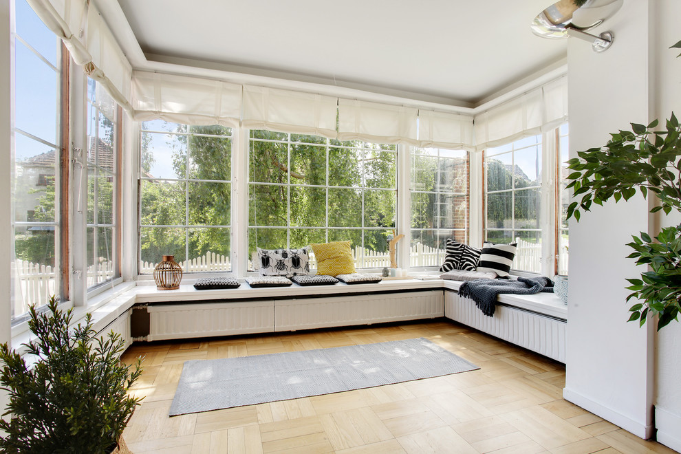 This is an example of a medium sized scandinavian conservatory in Copenhagen with light hardwood flooring.