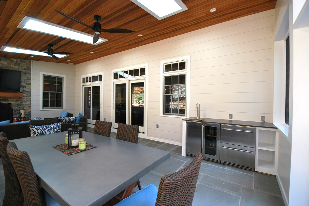 Modern inredning av ett mellanstort uterum, med skiffergolv, en standard öppen spis, en spiselkrans i sten, takfönster och blått golv