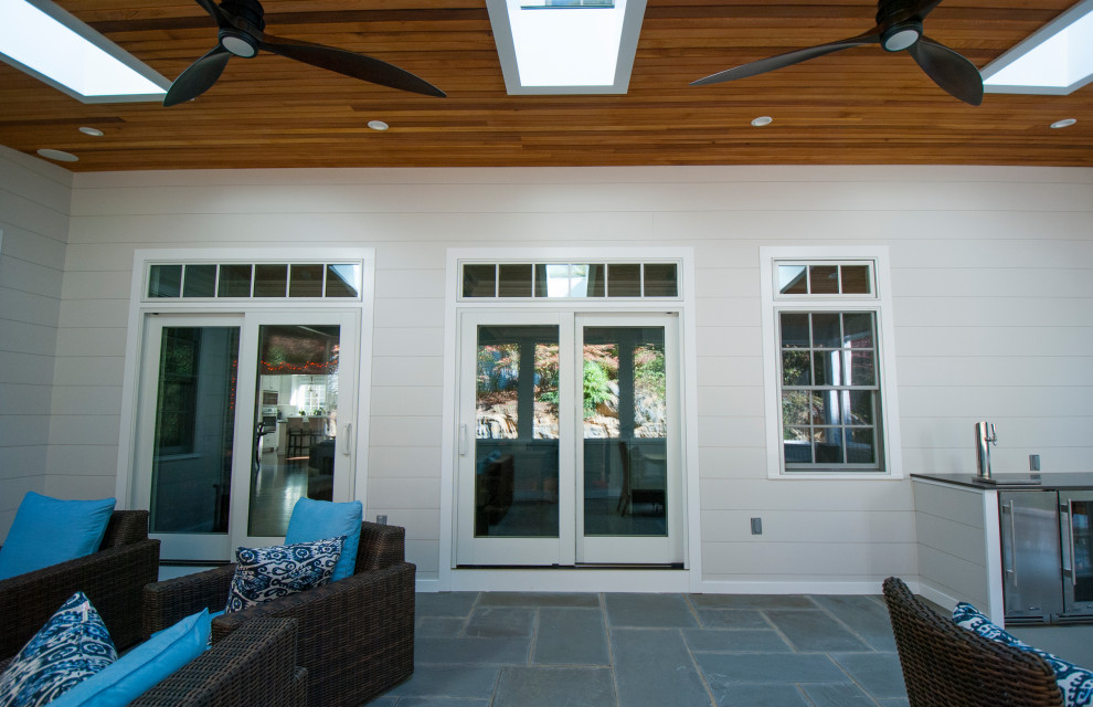 Идея дизайна: терраса среднего размера в современном стиле с полом из сланца, стандартным камином, фасадом камина из камня, потолочным окном и синим полом