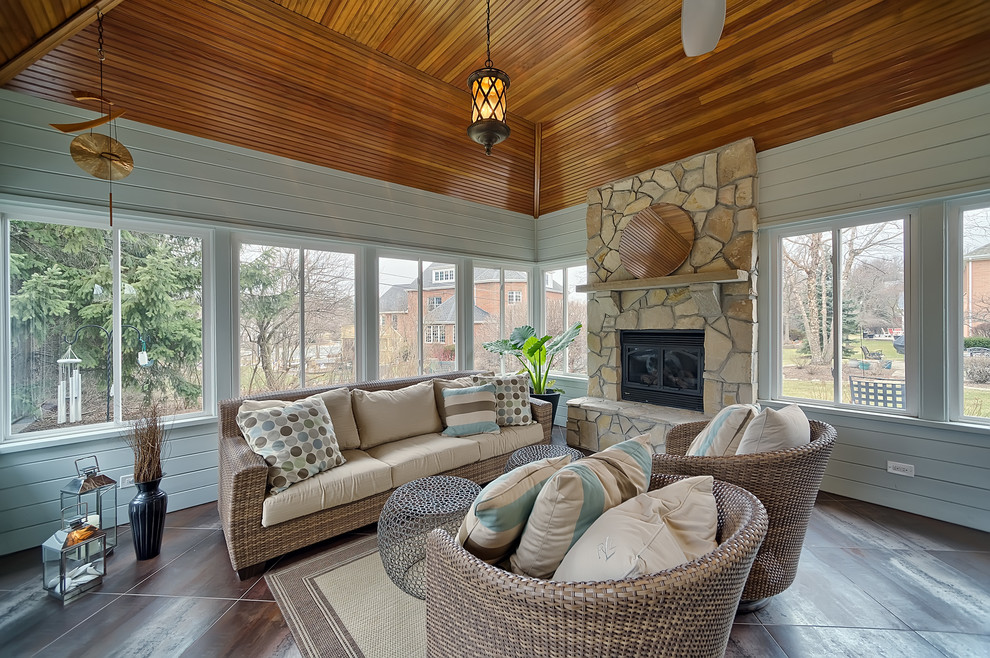 Sunroom - large traditional concrete floor and brown floor sunroom idea in Chicago with a standard fireplace, a stone fireplace and a standard ceiling