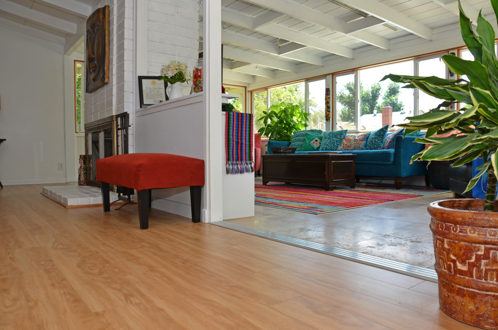 This is an example of a medium sized eclectic conservatory in Los Angeles with laminate floors, no fireplace, a standard ceiling and brown floors.
