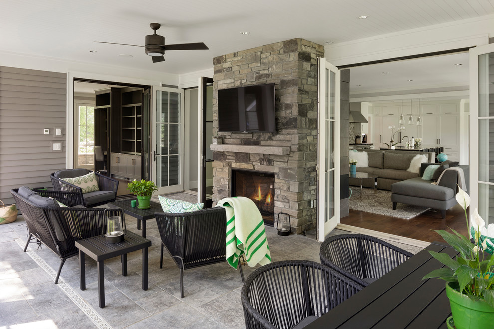 This is an example of a large classic conservatory in Minneapolis with slate flooring, a wood burning stove, a stone fireplace surround, a standard ceiling and grey floors.