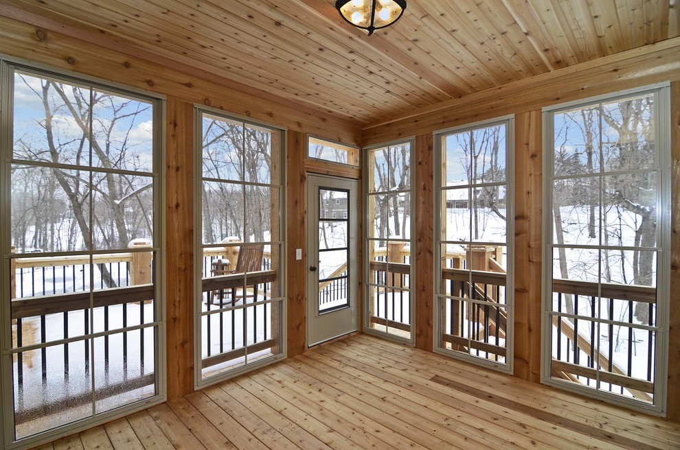 Immagine di una veranda stile rurale con pavimento in legno massello medio e soffitto classico
