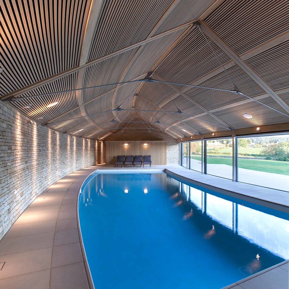 Imagen de piscina actual a medida y interior con suelo de baldosas