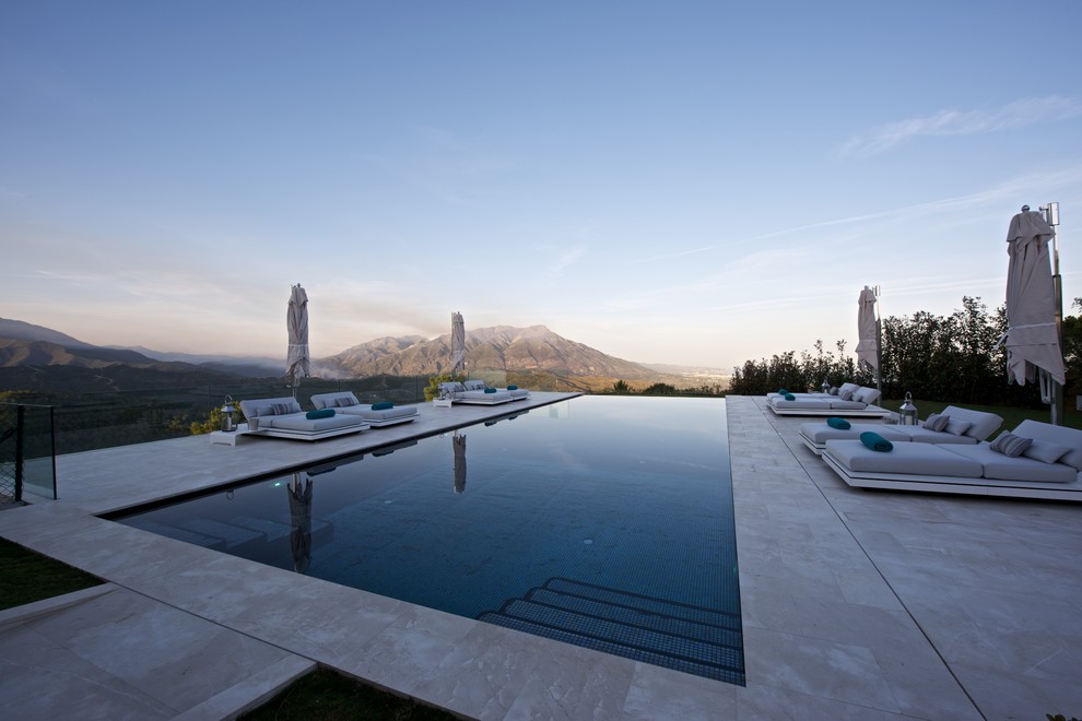 Foto de casa de la piscina y piscina infinita mediterránea grande rectangular en patio trasero con suelo de baldosas