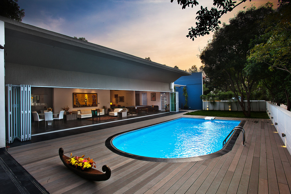 Großer Moderner Pool hinter dem Haus in Nierenform mit Dielen in Bangalore