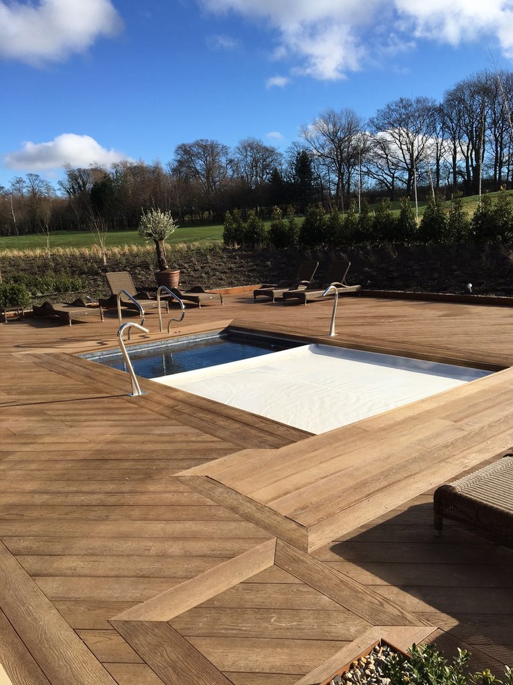 Idée de décoration pour une piscine hors-sol et arrière nordique avec une terrasse en bois.