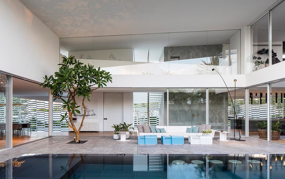 Inspiration for a huge contemporary courtyard tile and custom-shaped pool remodel in Other