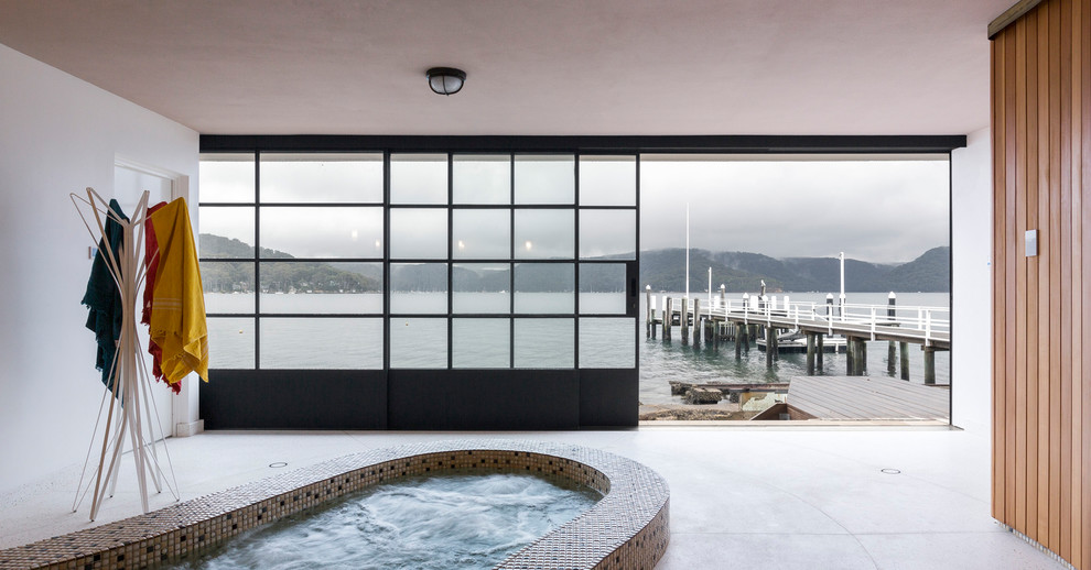 На фото: бассейн в доме в современном стиле с джакузи