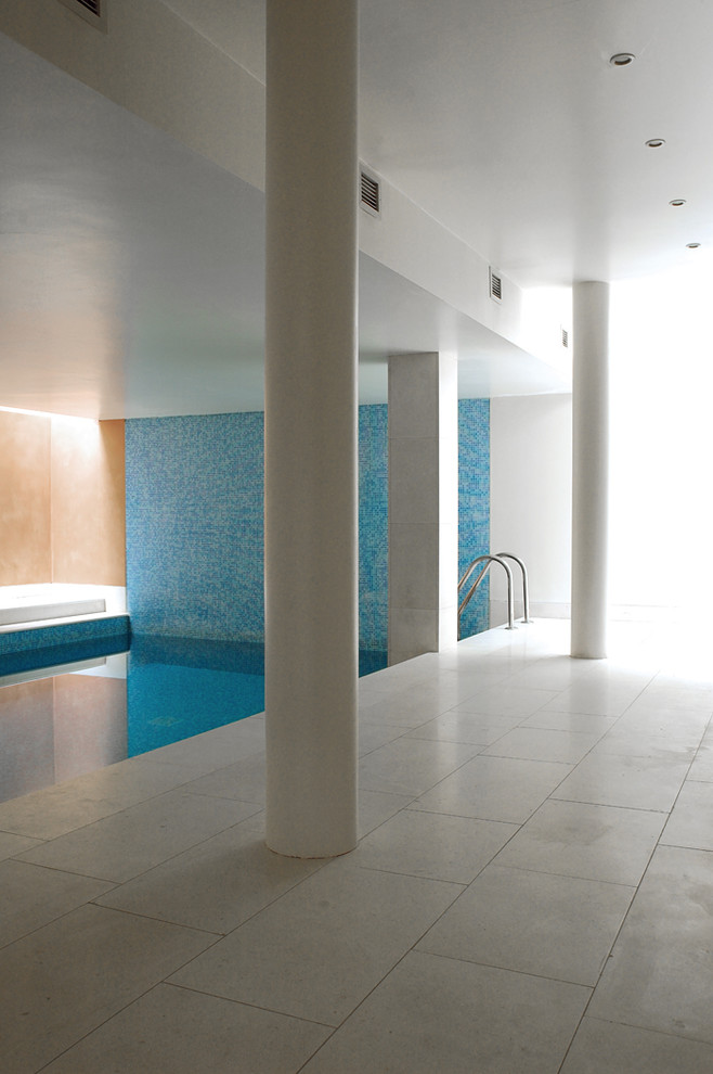 На фото: большой естественный, прямоугольный бассейн в доме в современном стиле с джакузи и покрытием из каменной брусчатки с