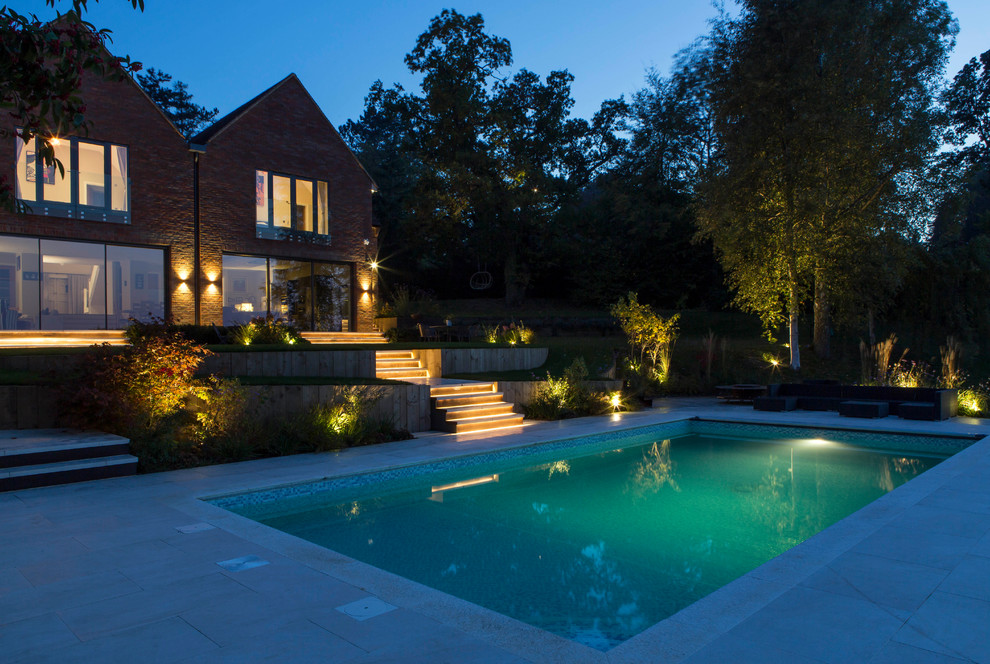 Inspiration for a medium sized contemporary back rectangular swimming pool in Buckinghamshire with natural stone paving.