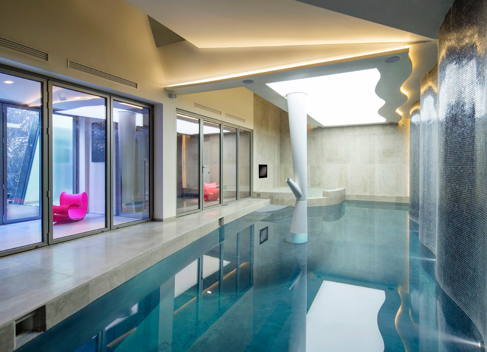Contemporary indoor custom shaped swimming pool in London with concrete slabs.
